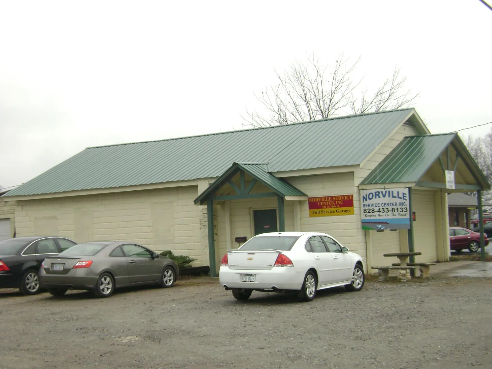 Green metal roof on a service garage with a covered entry in Genoa